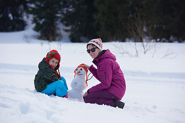 Image showing happy family building snowman