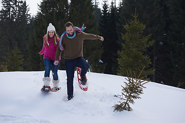 Image showing couple having fun and walking in snow shoes