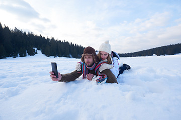Image showing romantic couple have fun in fresh snow and taking selfie