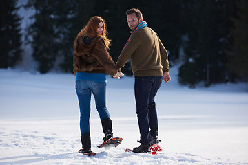 Image showing couple having fun and walking in snow shoes