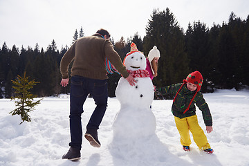 Image showing happy family building snowman