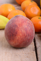 Image showing Bananas apple mandarin peach strawberry on wooden background as health food concept