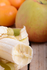 Image showing Mandarin Apples and Bananas on wooden plate