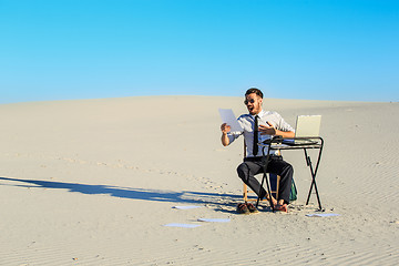 Image showing Businessman using  laptop in a desert