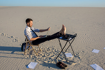 Image showing Businessman using  laptop in a desert