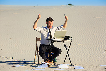 Image showing Businessman using  laptop in a desert