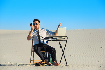 Image showing Businessman using  laptop in a desert