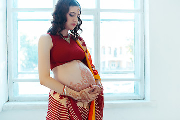 Image showing The pregnant woman belly with henna tattoo