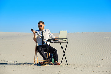 Image showing Businessman using  laptop in a desert