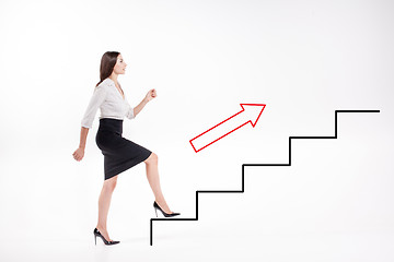 Image showing Young businesswoman walking up on stairs