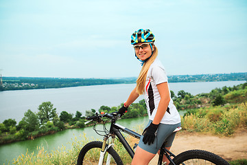 Image showing Young girl riding bicycle outside. Healthy Lifestyle.