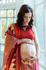 Image showing The pregnant woman belly with henna tattoo