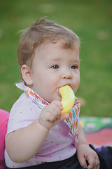 Image showing Baby, less than a year old   playing with  toy banana 