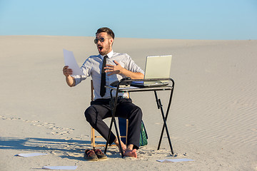 Image showing Businessman using  laptop in a desert