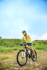 Image showing Young girl riding bicycle outside. Healthy Lifestyle.