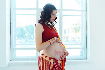 Image showing The pregnant woman belly with henna tattoo