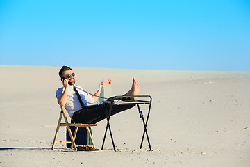 Image showing Businessman using  laptop in a desert