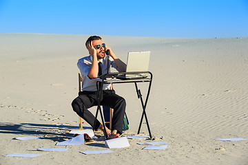 Image showing Businessman using  laptop in a desert