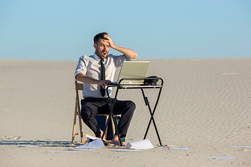 Image showing Businessman using  laptop in a desert