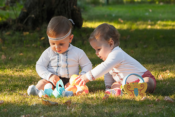 Image showing Babys, less than a year old, playing with  toys 