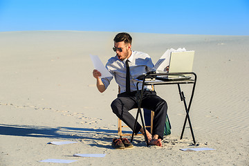 Image showing Businessman using  laptop in a desert