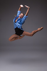 Image showing Young beautiful modern style dancer jumping in a studio background