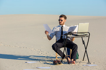 Image showing Businessman using  laptop in a desert