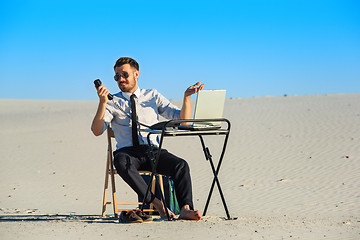 Image showing Businessman using  laptop in a desert