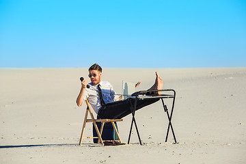 Image showing Businessman using  laptop in a desert