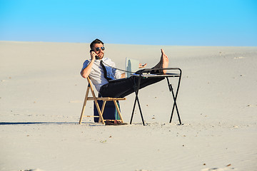 Image showing Businessman using  laptop in a desert