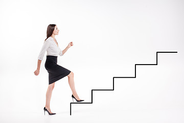 Image showing Young businesswoman walking up on stairs