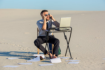 Image showing Businessman using  laptop in a desert