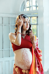 Image showing The pregnant woman belly with henna tattoo