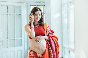 Image showing The pregnant woman belly with henna tattoo
