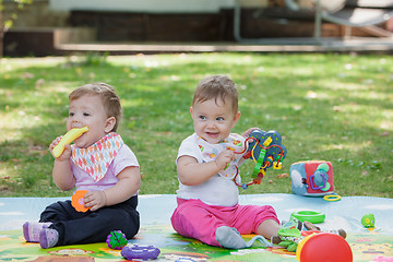 Image showing Babys, less than a year old, playing with  toys 