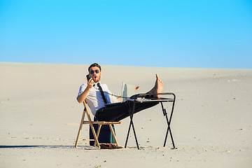 Image showing Businessman using  laptop in a desert