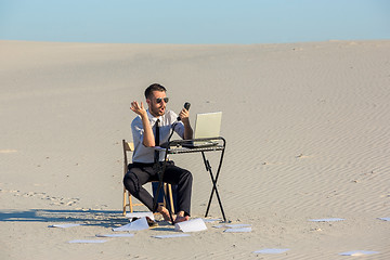 Image showing Businessman using  laptop in a desert