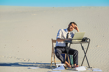 Image showing Businessman using  laptop in a desert