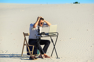 Image showing Businessman using  laptop in a desert