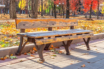 Image showing Lonely old bench in autumn city park on a sunny day