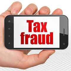 Image showing Law concept: Hand Holding Smartphone with Tax Fraud on display