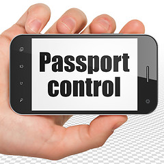Image showing Vacation concept: Hand Holding Smartphone with Passport Control on display