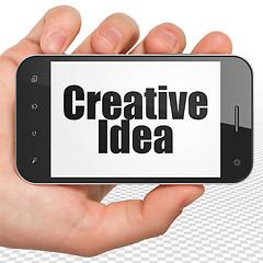 Image showing Business concept: Hand Holding Smartphone with Creative Idea on display