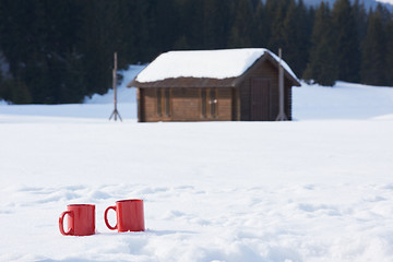 Image showing two red coups of hot tea drink in snow  at winter