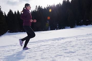 Image showing yougn woman jogging outdoor on snow in forest