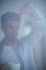 Image showing relaxed young man drink first morning coffee withh rain drops on