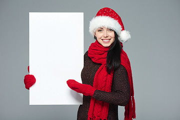 Image showing Woman in Santa hat holding white banner