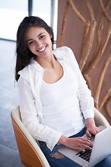 Image showing relaxed young woman at home working on laptop computer