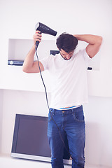 Image showing handsome man using  hairdryer