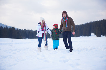 Image showing happy family playing together in snow at winter